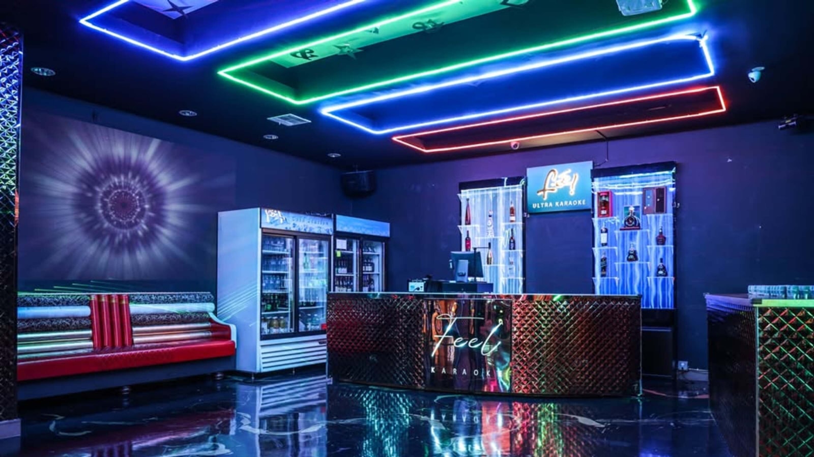 Un salón de estilo lounge con luces de neón moradas y una barra al fondo